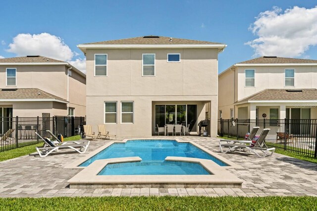 rear view of property with fence, a patio, and stucco siding