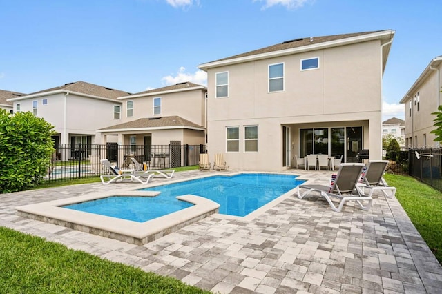 rear view of property featuring stucco siding, a fenced backyard, a fenced in pool, and a patio