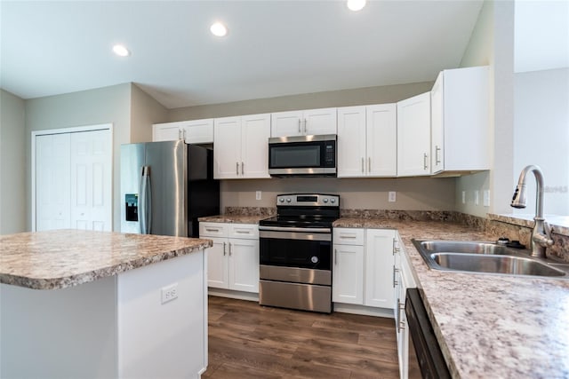 kitchen featuring dark wood finished floors, recessed lighting, a sink, white cabinets, and appliances with stainless steel finishes