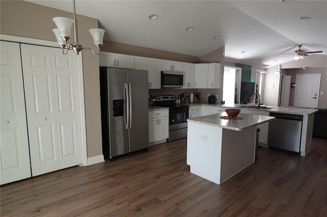 kitchen featuring a center island, vaulted ceiling, a peninsula, white cabinets, and stainless steel appliances