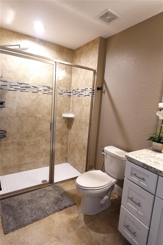 full bathroom featuring visible vents, a shower stall, toilet, tile patterned floors, and vanity