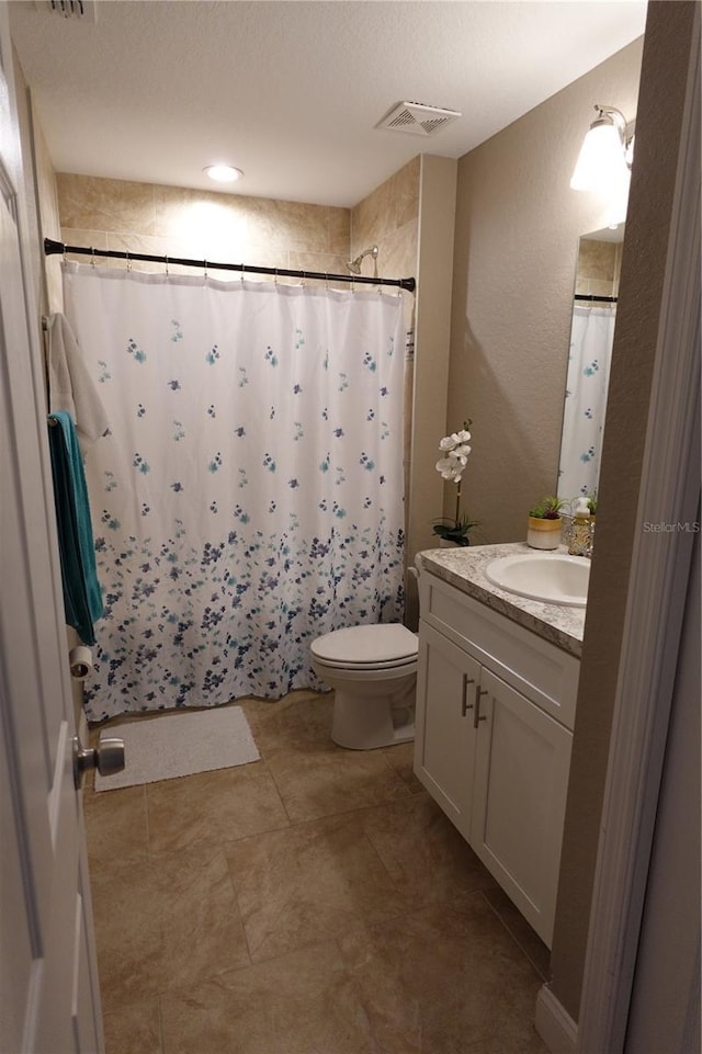 full bath with visible vents, curtained shower, toilet, and vanity