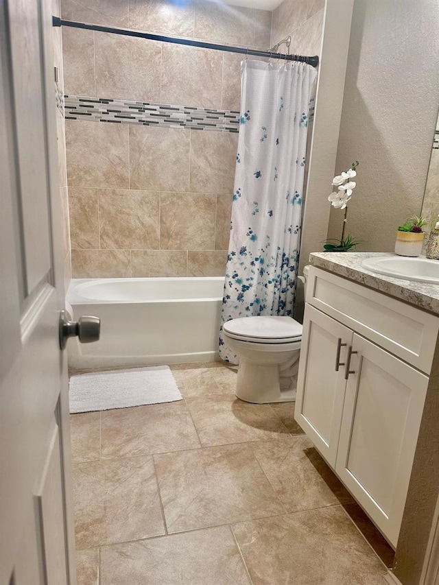 bathroom with toilet, vanity, a textured wall, and shower / bathtub combination with curtain