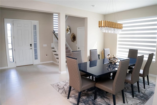 dining room featuring stairs, light tile patterned flooring, and baseboards