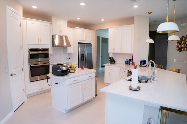 kitchen featuring under cabinet range hood, stainless steel appliances, a sink, light countertops, and a center island