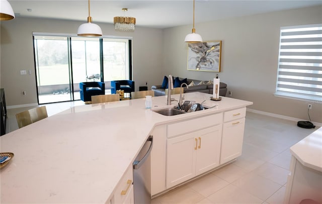 kitchen featuring stainless steel dishwasher, a sink, white cabinetry, and pendant lighting