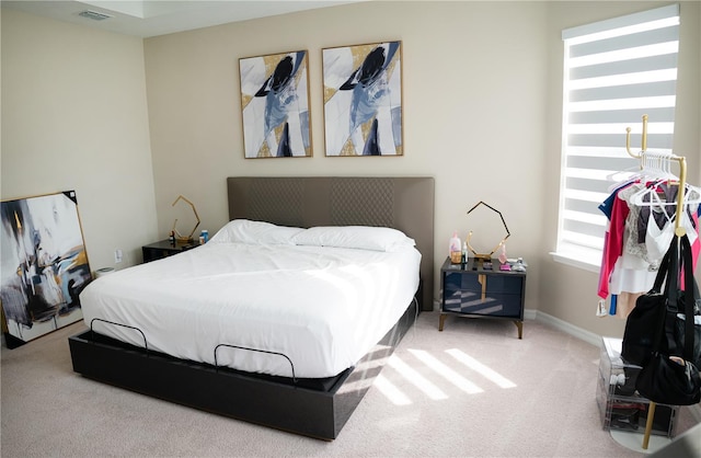 carpeted bedroom featuring visible vents and baseboards