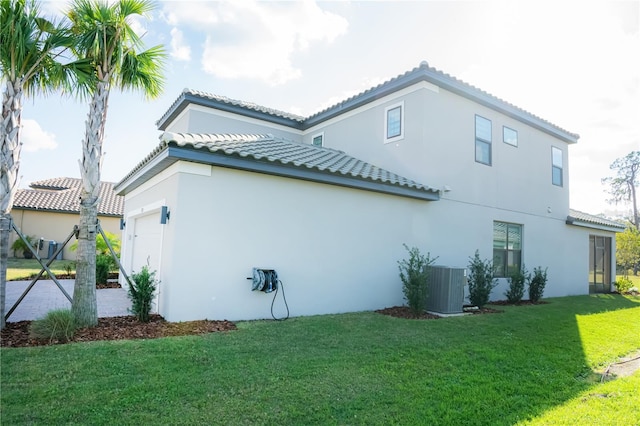 view of property exterior featuring a garage, a tiled roof, central AC unit, and stucco siding