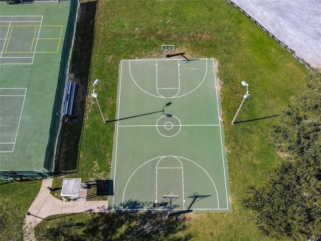 view of basketball court featuring a yard and basketball hoop