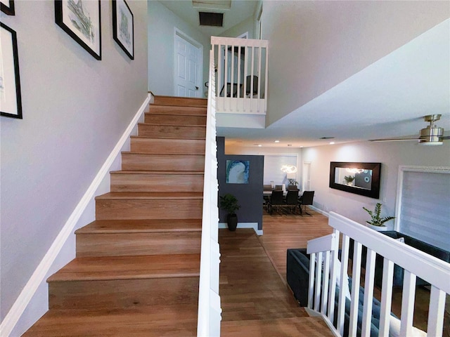 staircase with baseboards and wood finished floors