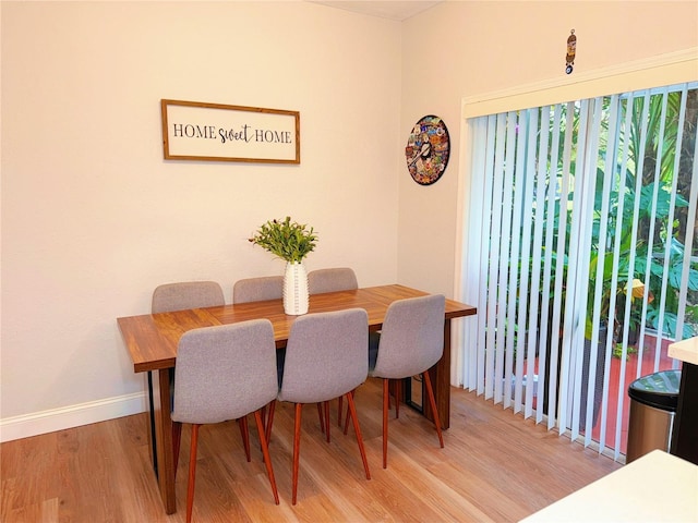 dining space with baseboards and wood finished floors