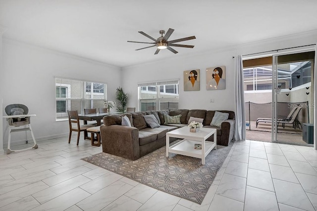 living room featuring ornamental molding, baseboards, a wealth of natural light, and ceiling fan