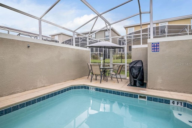 view of swimming pool with a lanai, a patio area, and grilling area