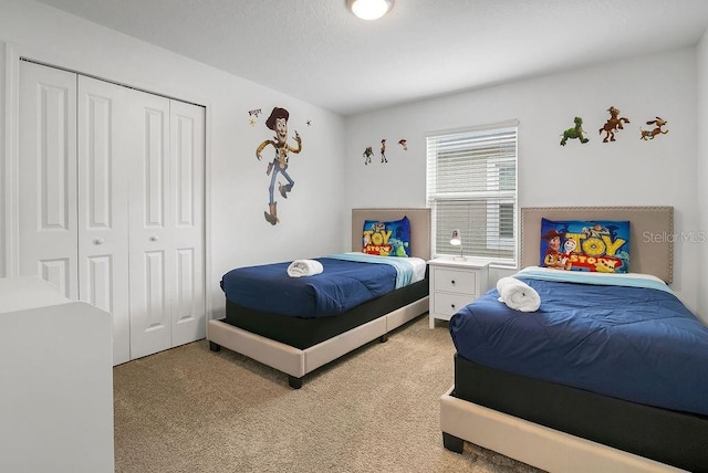 bedroom featuring light colored carpet and a closet