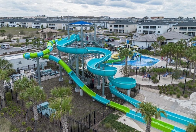 community playground with a residential view and fence