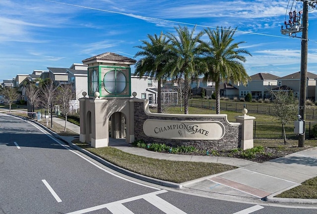 community sign featuring a residential view, a yard, and fence