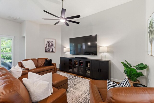 living room with ceiling fan, wood finished floors, and baseboards