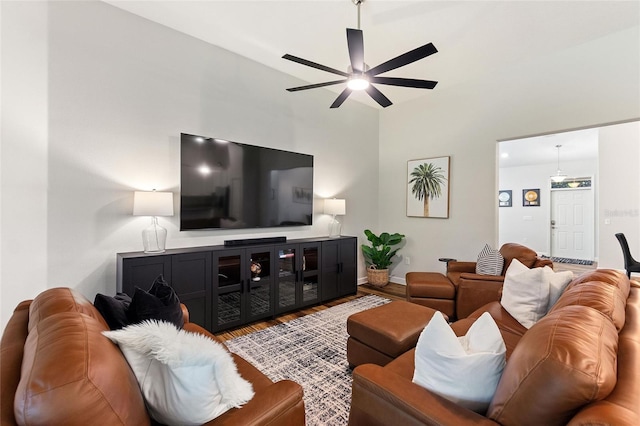 living room with a ceiling fan, baseboards, and wood finished floors