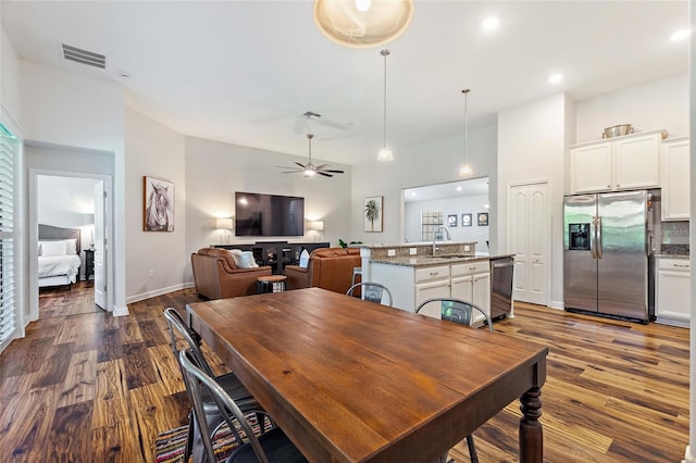 dining area featuring ceiling fan, dark wood-style flooring, visible vents, and baseboards