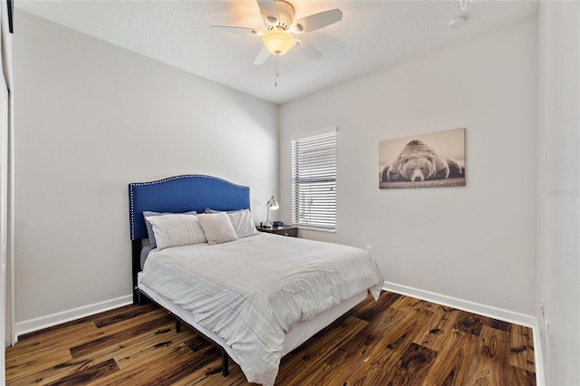 bedroom featuring a ceiling fan, baseboards, and wood finished floors