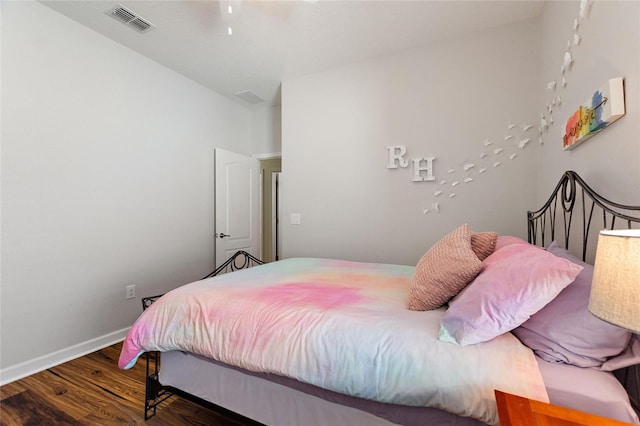 bedroom featuring baseboards, visible vents, and wood finished floors