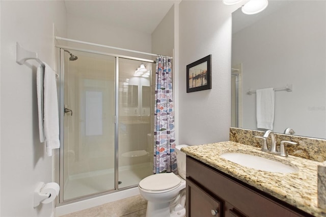 bathroom with a stall shower, vanity, toilet, and tile patterned floors