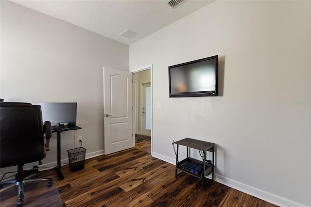 office area with dark wood-style flooring, visible vents, and baseboards