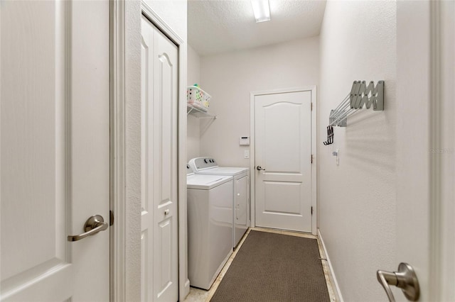 laundry area featuring laundry area, baseboards, separate washer and dryer, and a textured ceiling