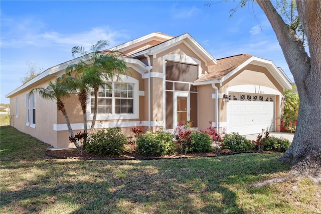 view of front of house with a garage, concrete driveway, a front lawn, and stucco siding