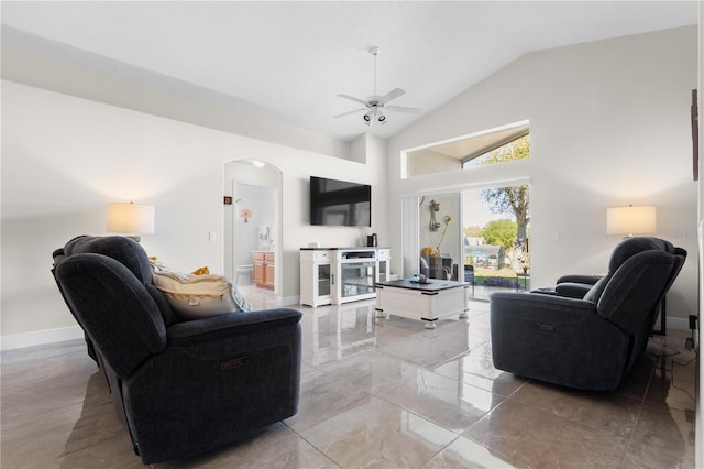 living area with arched walkways, marble finish floor, ceiling fan, high vaulted ceiling, and baseboards