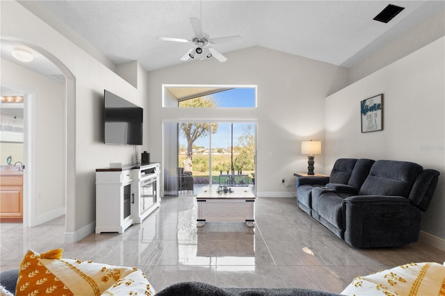 living area featuring arched walkways, ceiling fan, high vaulted ceiling, baseboards, and marble finish floor