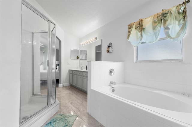 full bathroom with a stall shower, a garden tub, vanity, and a textured ceiling