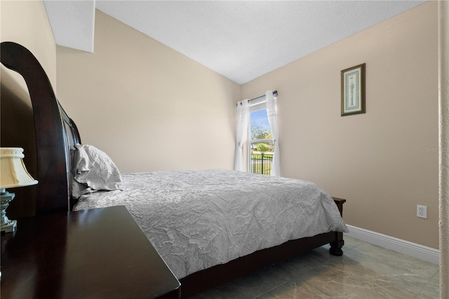 bedroom with baseboards and vaulted ceiling