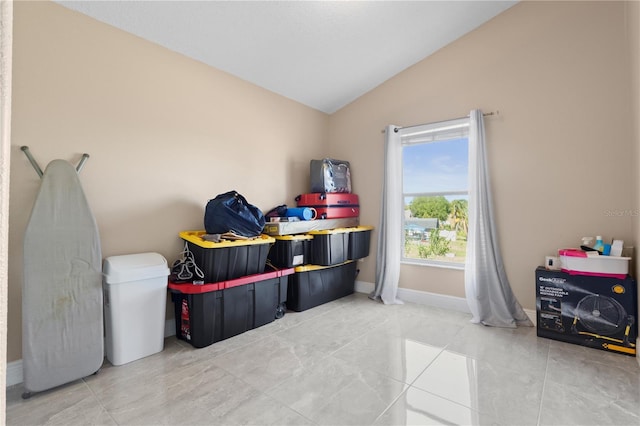 recreation room with vaulted ceiling, baseboards, and light tile patterned floors