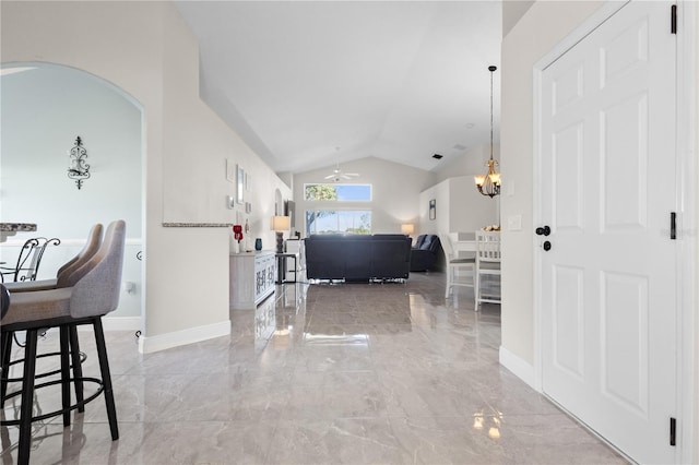 entryway with arched walkways, a chandelier, baseboards, vaulted ceiling, and marble finish floor