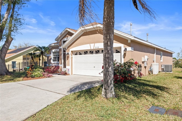 view of front of home with a garage, central AC, fence, stucco siding, and a front yard