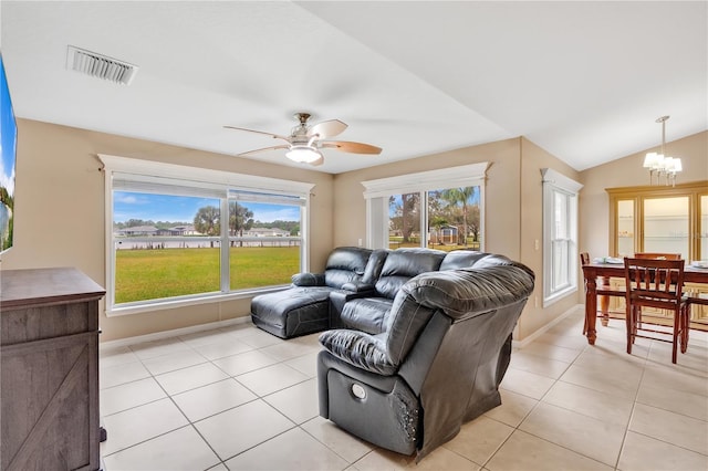 living room with light tile patterned floors, lofted ceiling, visible vents, baseboards, and ceiling fan with notable chandelier