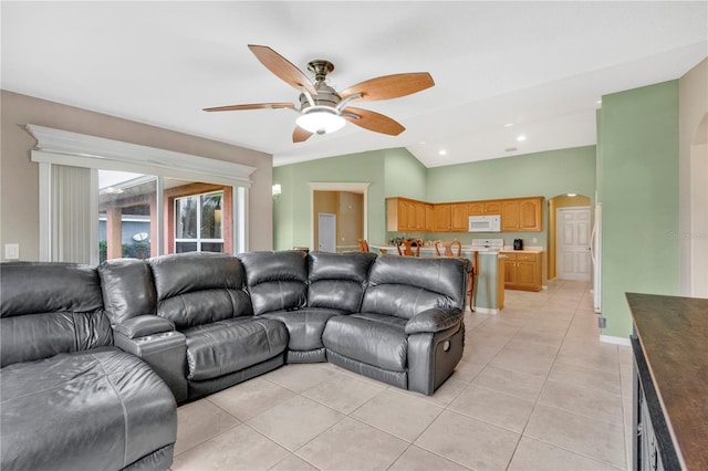 living room featuring arched walkways, light tile patterned floors, recessed lighting, ceiling fan, and vaulted ceiling