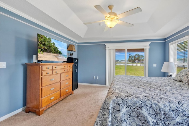 bedroom with light carpet, access to outside, a tray ceiling, and baseboards