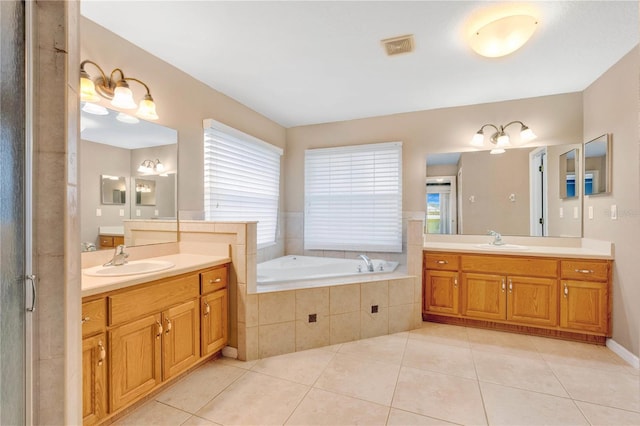 full bathroom featuring a bath, visible vents, a sink, and tile patterned floors