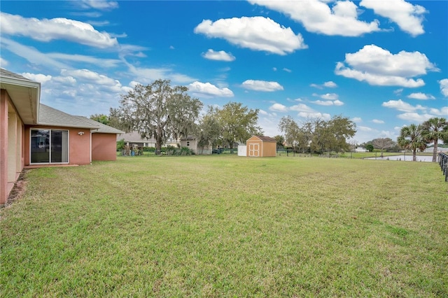 view of yard with a shed, fence, and an outdoor structure