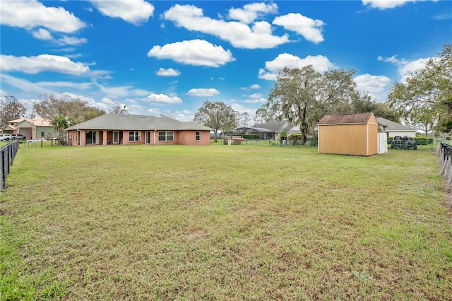 view of yard with a fenced backyard, a storage unit, and an outdoor structure