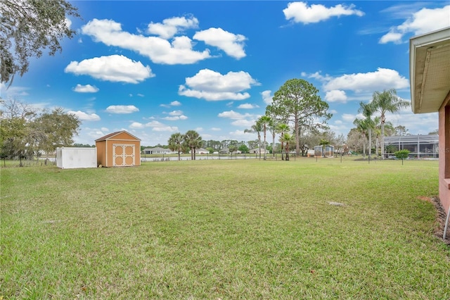 view of yard with an outdoor structure, fence, and a shed