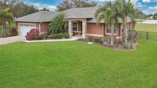 view of front of property with a garage, a front yard, fence, and stucco siding