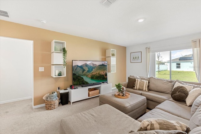 living room with carpet, visible vents, and baseboards