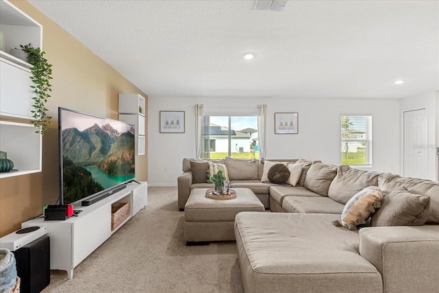 living room featuring light carpet, visible vents, and recessed lighting