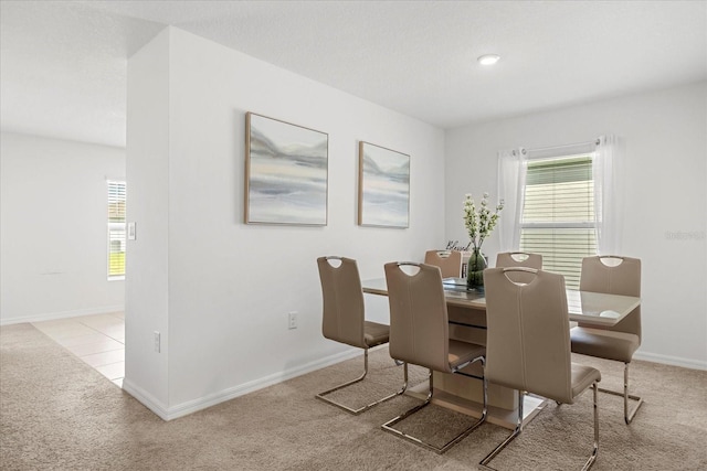 carpeted dining area featuring plenty of natural light and baseboards