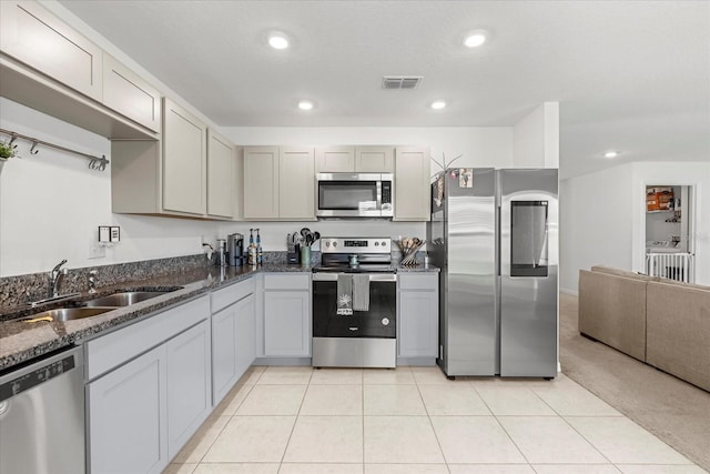 kitchen with recessed lighting, a sink, visible vents, appliances with stainless steel finishes, and dark stone counters