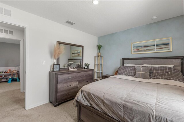 carpeted bedroom featuring baseboards and visible vents