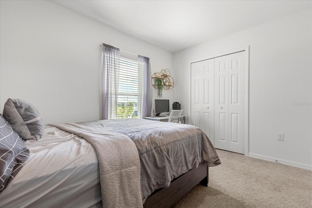 carpeted bedroom featuring a closet and baseboards